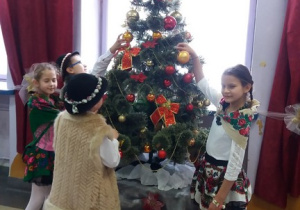 uczniowie w góralskich strojach przy stole wigilijnym