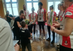 uczniowie wręczają kwaity zawodniczkom Łódzkiego Klubu Sportowego