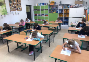 uczniowie w trakcie pisania pracy konkursowej