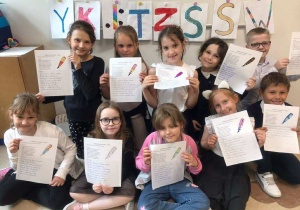 grupa uczniów prezentujących swoje prace