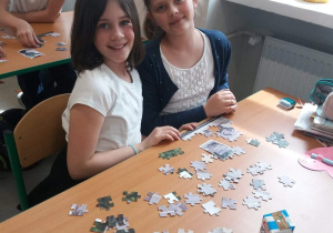 uczniowie układający puzzle