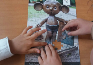uczniowie układający puzzle