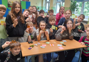 grupa uczniów ze swoimi pracami - literami wykonanymi za pomocą długopisu 3D